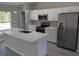 Modern kitchen featuring white cabinets, stainless steel appliances, and an island at 90 Bay Dr, Ocklawaha, FL 32179