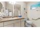 Bathroom featuring a single sink vanity with stone countertop, toilet, and walk-in shower with glass doors at 973 Buster Pl, The Villages, FL 32162