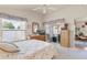 Light filled bedroom with floral valances, dresser and TV, with sliding doors to screened in porch at 973 Buster Pl, The Villages, FL 32162