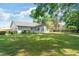 Spacious backyard featuring mature trees, lush grass, and a screened porch at 4360 Se 58Th Pl, Ocala, FL 34480