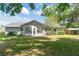 Backyard view of a home with a screened porch and mature trees at 4360 Se 58Th Pl, Ocala, FL 34480