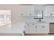Kitchen featuring white cabinets, quartz countertops, and stainless sink at 4360 Se 58Th Pl, Ocala, FL 34480