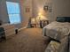 Cozy bedroom featuring soft carpet, natural light from the window, and quaint decor at 19370 Saint Benedict Dr, Dunnellon, FL 34432