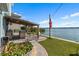 Backyard boasts an outdoor kitchen and bar area, a lush lawn, and serene waterfront views for the best in outdoor living at 455 Blue Cypress Dr, Groveland, FL 34736