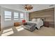 Bright bedroom with a decorative wood wall, lots of light from the windows, and a comfy sitting area for relaxing at 455 Blue Cypress Dr, Groveland, FL 34736