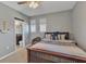 Cozy bedroom featuring a wood bed frame, natural light, and an attached bathroom for added convenience and privacy at 455 Blue Cypress Dr, Groveland, FL 34736