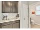 Elegant butler's pantry with granite countertops, custom cabinetry, and easy access to a convenient half-bathroom at 455 Blue Cypress Dr, Groveland, FL 34736