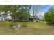 Backyard view of home with mature trees, a screen porch, and well-maintained lawn at 8150 Sw 108Th St, Ocala, FL 34481