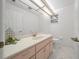 Bathroom featuring a wide mirror, under cabinet storage, a toilet, and a small window at 8150 Sw 108Th St, Ocala, FL 34481