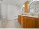 Bright bathroom with a double sink vanity, warm-toned wood cabinets, and a glass-enclosed shower at 8150 Sw 108Th St, Ocala, FL 34481