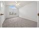 Well-lit bedroom with a large arched window, ceiling fan, and neutral carpet flooring at 8150 Sw 108Th St, Ocala, FL 34481