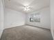 Spacious bedroom featuring neutral carpeting, a ceiling fan, and a sunlit window at 8150 Sw 108Th St, Ocala, FL 34481