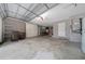 Open two-car garage featuring a work bench, extra storage, and a door leading to an extra refrigerator at 8150 Sw 108Th St, Ocala, FL 34481
