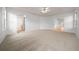 Spacious main bedroom with neutral carpet, a ceiling fan, and en-suite bathroom and access to another room at 8150 Sw 108Th St, Ocala, FL 34481