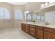 Spacious bathroom with double vanity, decorative mirrors, arched windows, and tile flooring at 10927 Se 168Th Loop, Summerfield, FL 34491