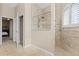 Bright bathroom featuring a tiled walk-in shower with a glass enclosure and view to the main bedroom at 10927 Se 168Th Loop, Summerfield, FL 34491