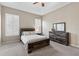 Serene bedroom featuring tray ceiling, plantation shutters, and rustic wood furniture at 10927 Se 168Th Loop, Summerfield, FL 34491