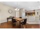 Dining room featuring hardwood floors, modern lighting fixture, and adjacent kitchen area at 10927 Se 168Th Loop, Summerfield, FL 34491