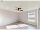 Bright bedroom with ceiling fan, wood-look tile floors, and a window at 11 Emerald Trl, Ocala, FL 34472