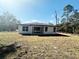 An exterior view of the home shows a well-maintained backyard with sliding glass doors and lush surroundings at 14711 Sw 69Th Court Rd, Ocala, FL 34473