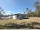 The home's backyard showcases a patio area and lots of lawn, with a view of the adjacent neighborhood at 14711 Sw 69Th Court Rd, Ocala, FL 34473