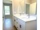 Bathroom with double vanity, quartz countertop, and wood-look tile flooring at 14711 Sw 69Th Court Rd, Ocala, FL 34473