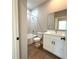 Bathroom features a shower-tub combo, white vanity, and wood-look tile flooring at 14711 Sw 69Th Court Rd, Ocala, FL 34473