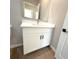 Bathroom vanity with a large mirror and white cabinets beneath the sink at 14711 Sw 69Th Court Rd, Ocala, FL 34473
