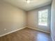 Bright bedroom with a large window and wood-look tile flooring at 14711 Sw 69Th Court Rd, Ocala, FL 34473