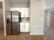 Bright kitchen features stainless steel refrigerator and white cabinets with black hardware at 14711 Sw 69Th Court Rd, Ocala, FL 34473