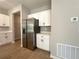 Bright kitchen features stainless steel refrigerator and white cabinets with black hardware at 14711 Sw 69Th Court Rd, Ocala, FL 34473