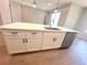 Kitchen island features a sink, dishwasher, and white cabinets with black hardware at 14711 Sw 69Th Court Rd, Ocala, FL 34473