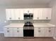 Modern kitchen boasts white cabinets, quartz countertops, and stainless steel appliances at 14711 Sw 69Th Court Rd, Ocala, FL 34473