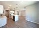 Modern kitchen featuring a central island, stainless steel appliances, and an open floor plan with wood-look tile flooring at 14711 Sw 69Th Court Rd, Ocala, FL 34473