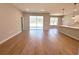 Spacious living room with wood-look tile flooring, sliding glass doors, and an open view to the kitchen at 14711 Sw 69Th Court Rd, Ocala, FL 34473