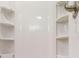 Bright white stand-up shower with built-in shelving for storage of personal items and toiletries at 21114 Sw Peach Blossom St, Dunnellon, FL 34431