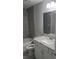 Well-lit bathroom featuring modern fixtures, gray tiling and granite countertops at 22084 Sw Rainbow Lakes Blvd, Dunnellon, FL 34431