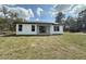 Exterior shot of the home's rear facade, highlighting windows and sliding glass doors at 2647 Sw 154Th Ln, Ocala, FL 34473