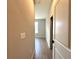 Hallway with neutral paint, wood-look tile flooring, and access to a bedroom with natural light at 2647 Sw 154Th Ln, Ocala, FL 34473