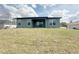The backyard has a grassy hill and a home exterior with large windows and sliding glass doors at 3015 Sw 132Nd St, Ocala, FL 34473