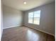 A sunny bedroom features wood-look tile flooring and a large window at 3015 Sw 132Nd St, Ocala, FL 34473