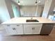 Kitchen island with white cabinetry, stainless steel dishwasher, and a sink at 3015 Sw 132Nd St, Ocala, FL 34473