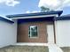 Close-up of the home's entrance with a contemporary door and stylish wood-look accent panel at 3547 Sw 130Th Lane Rd, Ocala, FL 34473