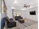 Bright living room featuring a ceiling fan, large TV and sliding doors to the lanai at 6200 Sw 72Nd Ter, Ocala, FL 34474