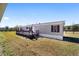 Tan mobile home with deck and yard at 10555 W Highway 40, Ocala, FL 34482