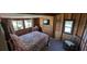 Cozy bedroom featuring a comfortable bed, wood paneled walls, and lots of natural light from the multiple windows at 14830 Se 61St Street Rd, Ocklawaha, FL 32179