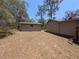 Backyard view of home and adjacent structure on a natural lot with mature landscaping at 14830 Se 61St Street Rd, Ocklawaha, FL 32179