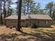 Rear exterior view of home with a lush natural backdrop of trees providing privacy and a connection with nature at 14830 Se 61St Street Rd, Ocklawaha, FL 32179
