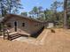 View of the home, stone walkway, and detached garage surrounded by mature trees and natural landscaping at 14830 Se 61St Street Rd, Ocklawaha, FL 32179