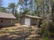 Exterior of the home's detached garage, offering additional storage and parking space on a wooded lot at 14830 Se 61St Street Rd, Ocklawaha, FL 32179